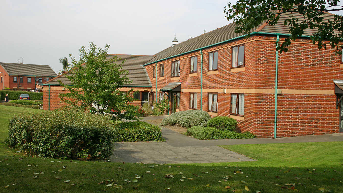 Exterior view of a senior living facility with landscaping