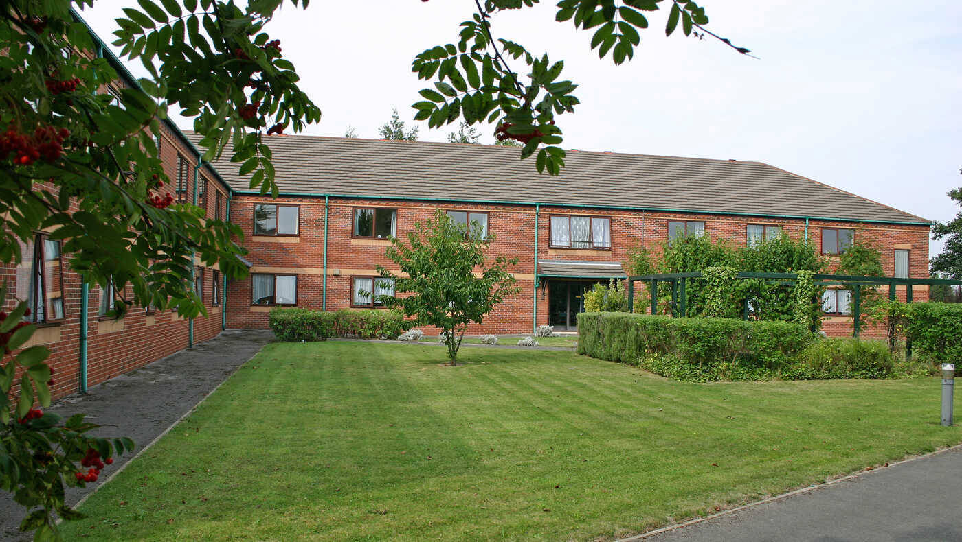 Exterior view of a senior living facility with gardens