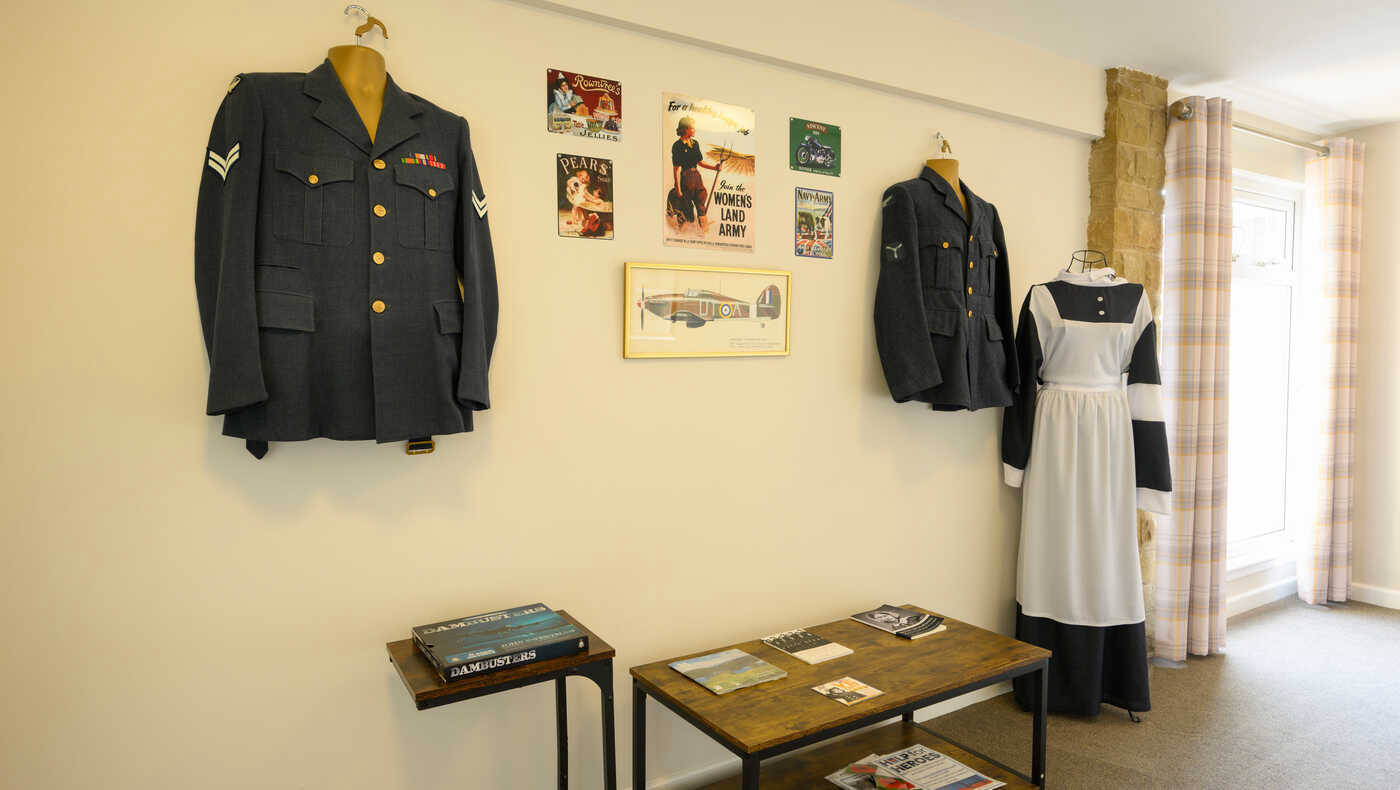 Historical military uniforms displayed on a wall