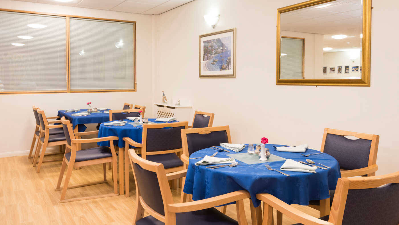 Dining area with blue tablecloths and flowers