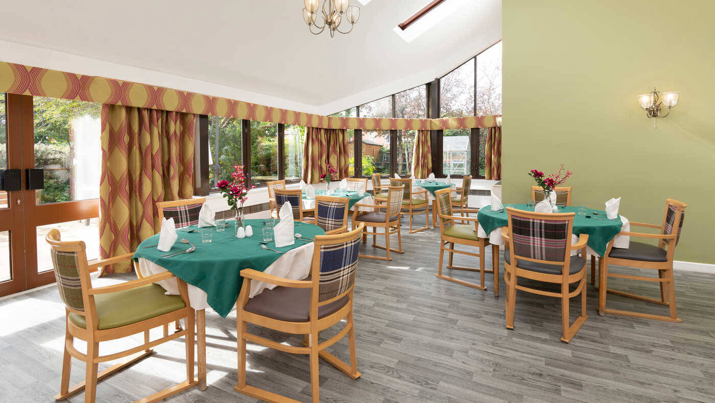 Dining room set with green tablecloths and flowers