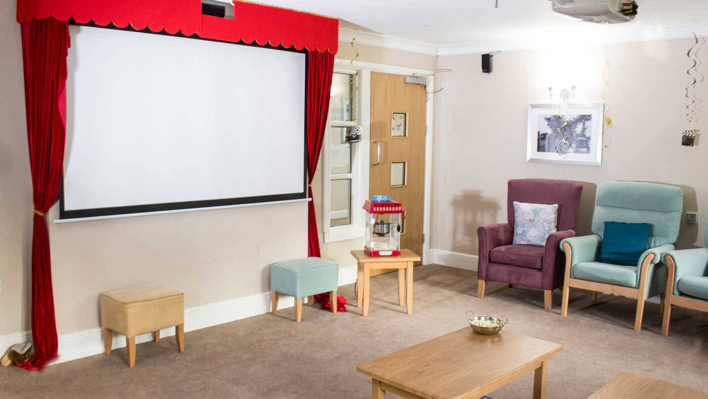 Cozy interior common area with seating and a projector screen