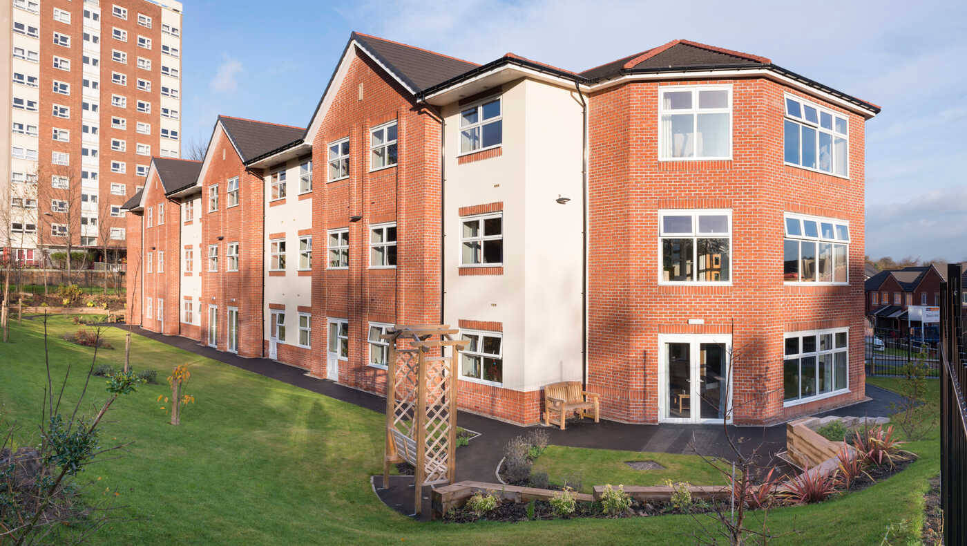 Exterior view of a nursing home building surrounded by greenery