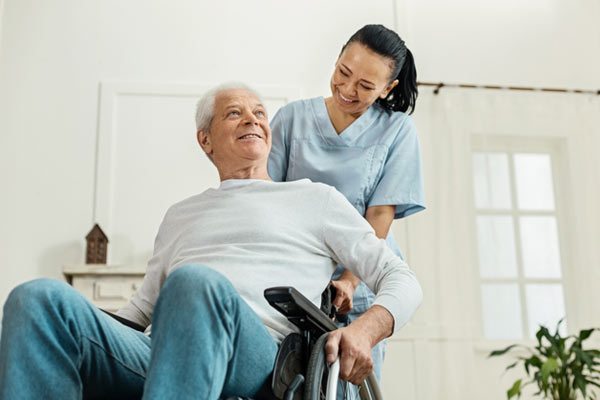 A caregiver assisting a resident in a wheelchair