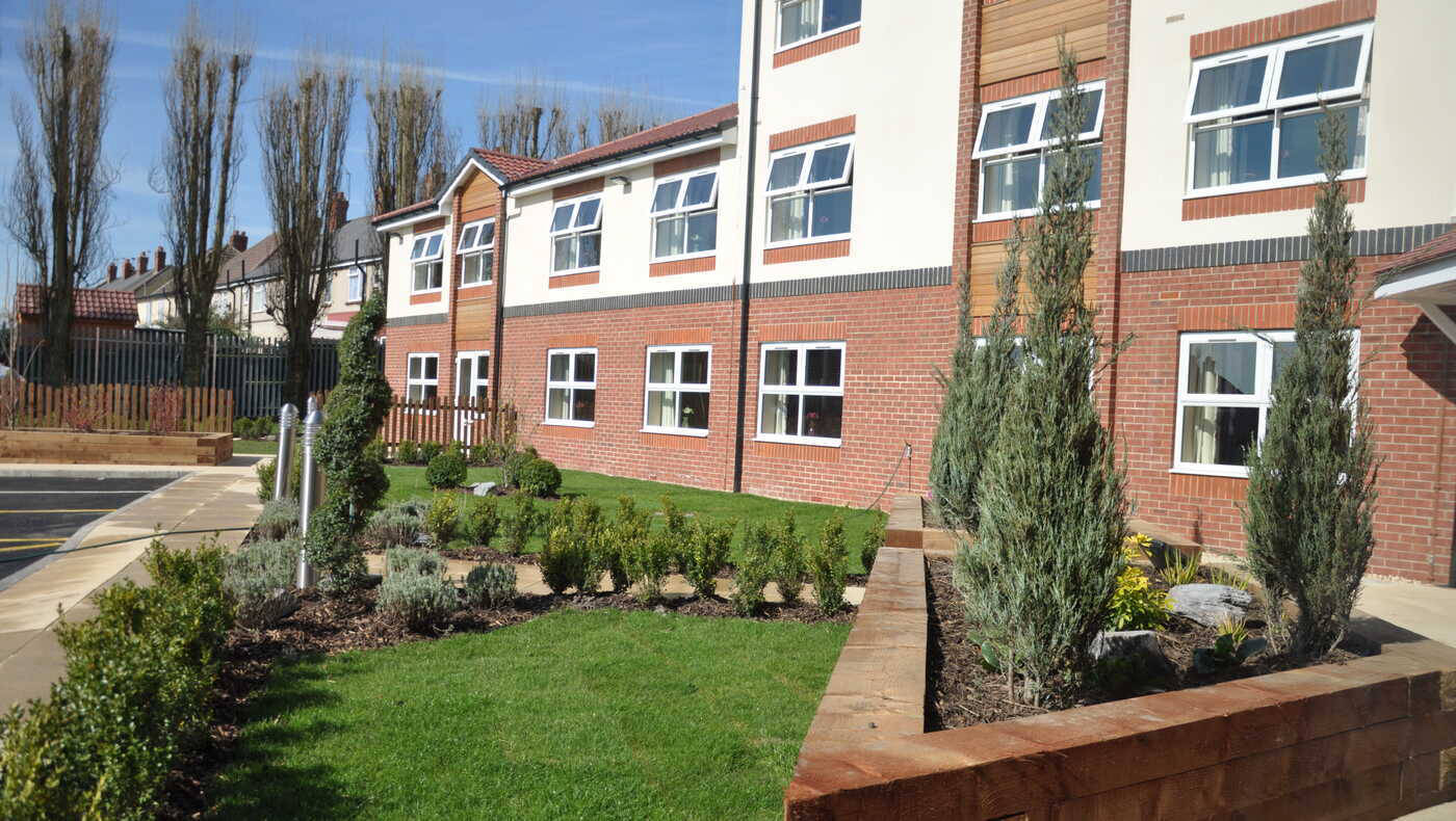 Exterior view of the facility with landscaped gardens