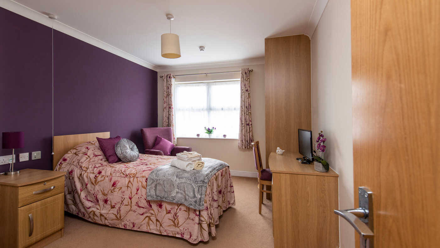 Cozy resident room with floral bedding and natural light