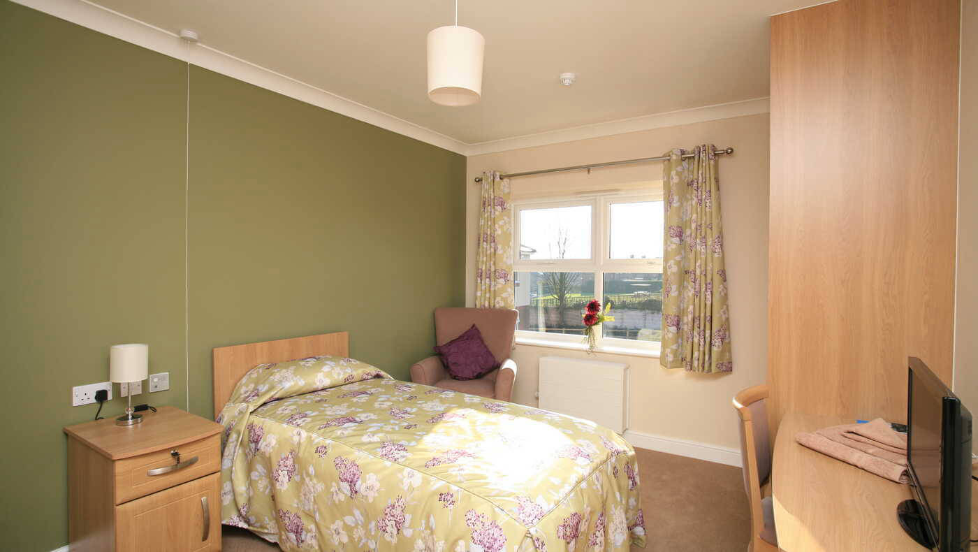Cozy resident room with a bed and chair