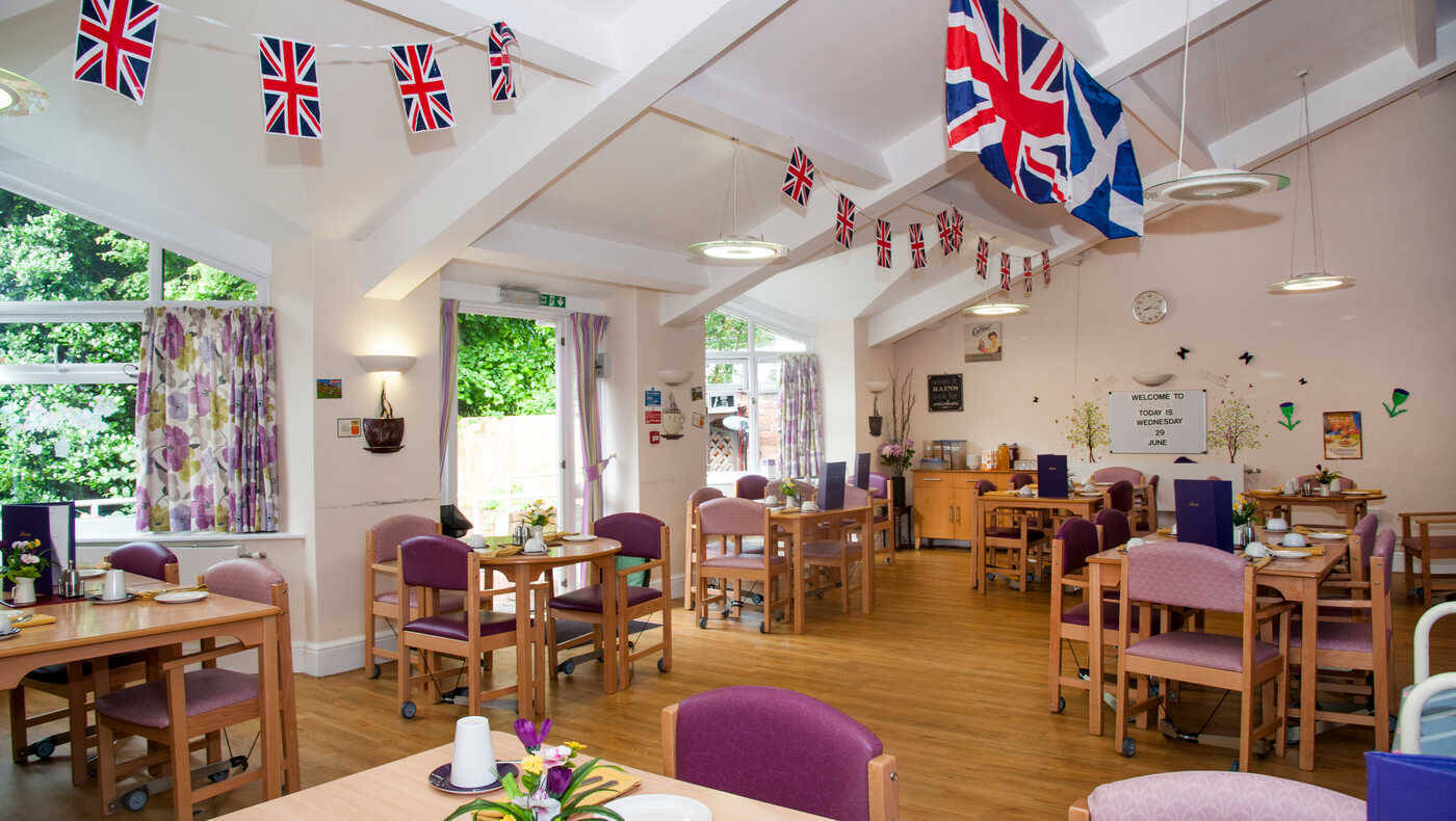 Bright dining room with tables set and bunting decorations