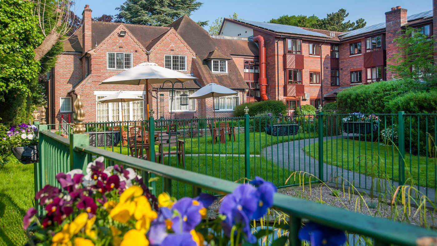 Exterior view of a senior living facility with gardens