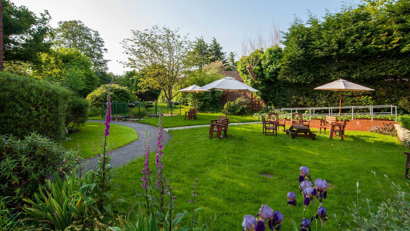 A serene garden area with seating and green landscaping