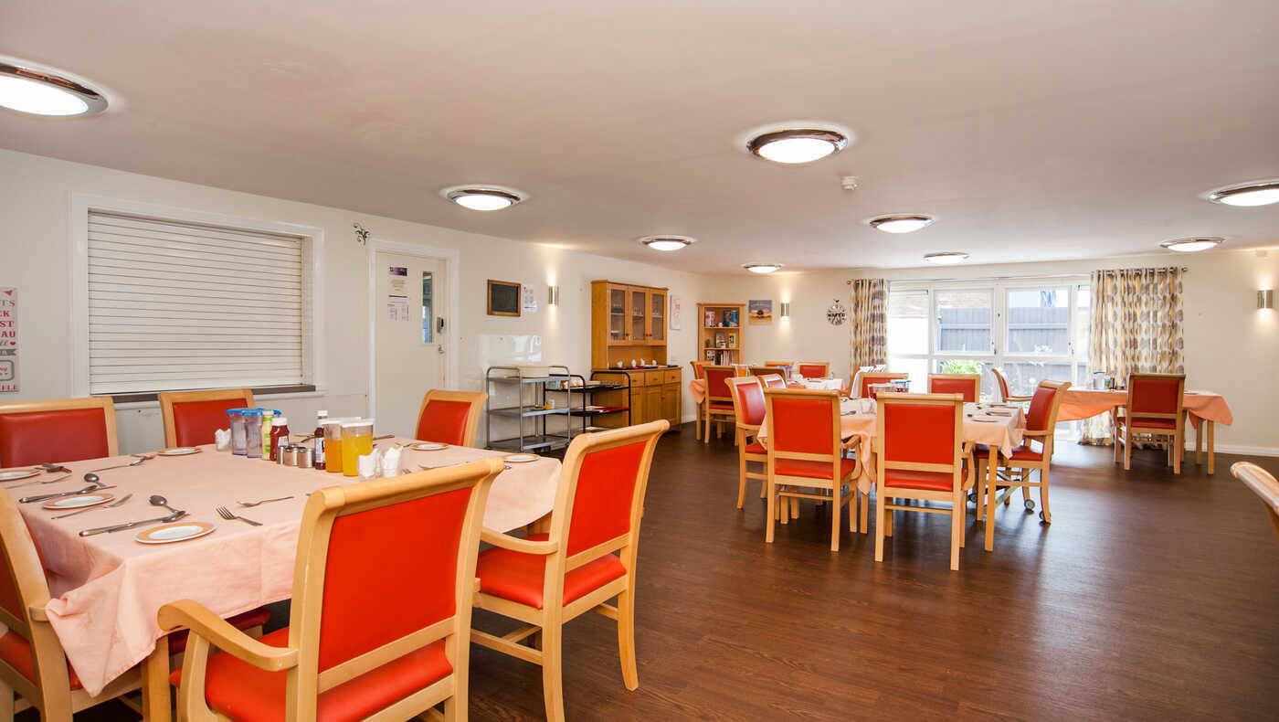 Bright dining room with orange chairs and tables