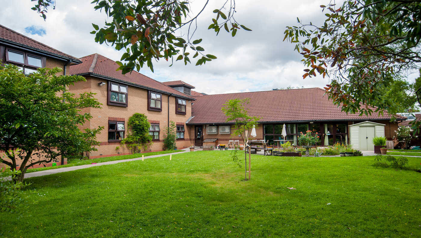 Exterior view of assisted living facility with garden