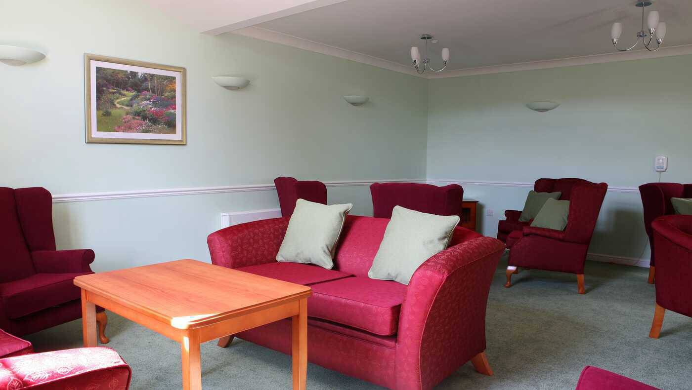 Cozy common area with red chairs and wooden table