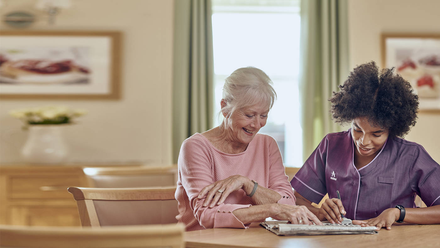 Resident and staff member engaging at a table