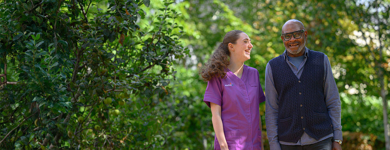 Staff member walking with resident in a garden