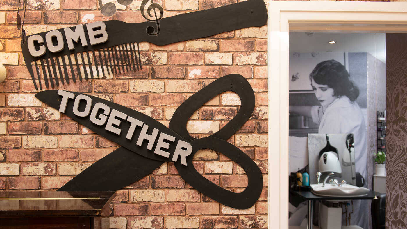 Decorative salon sign with scissors and comb