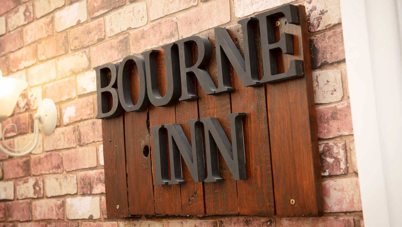 Wooden sign reading Bourne Inn
