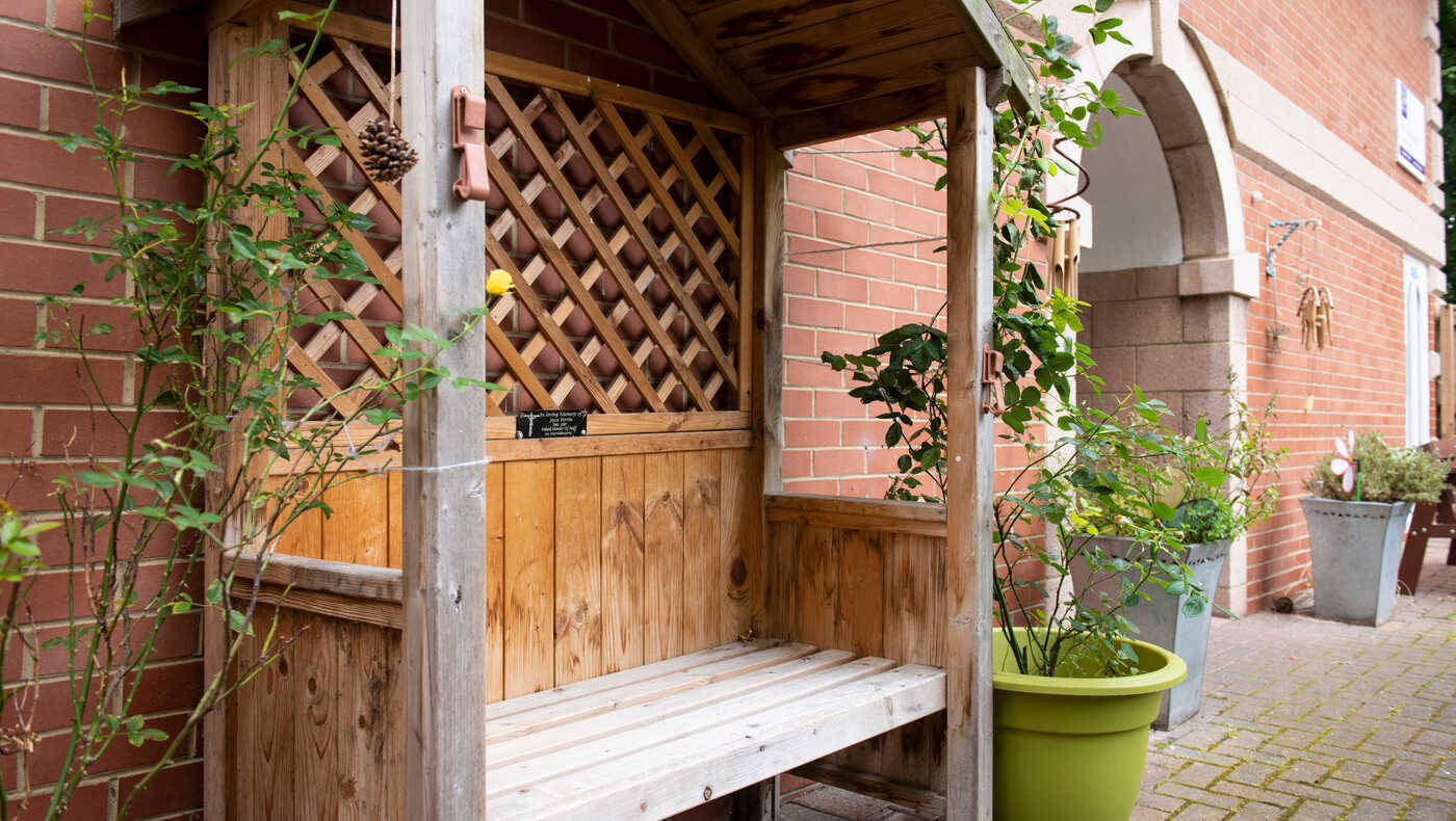 A wooden bench with plants in an outdoor area