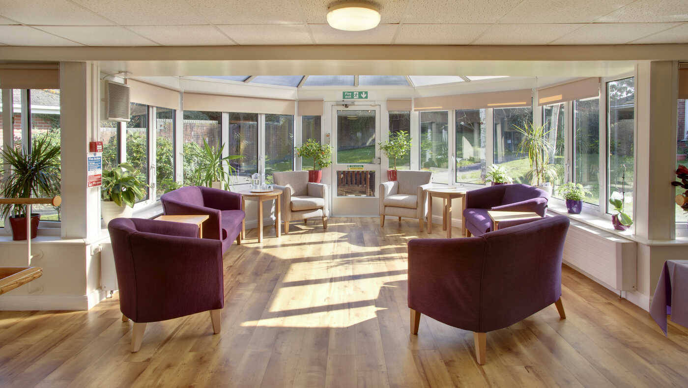 Bright, sunlit common area with seating and plants