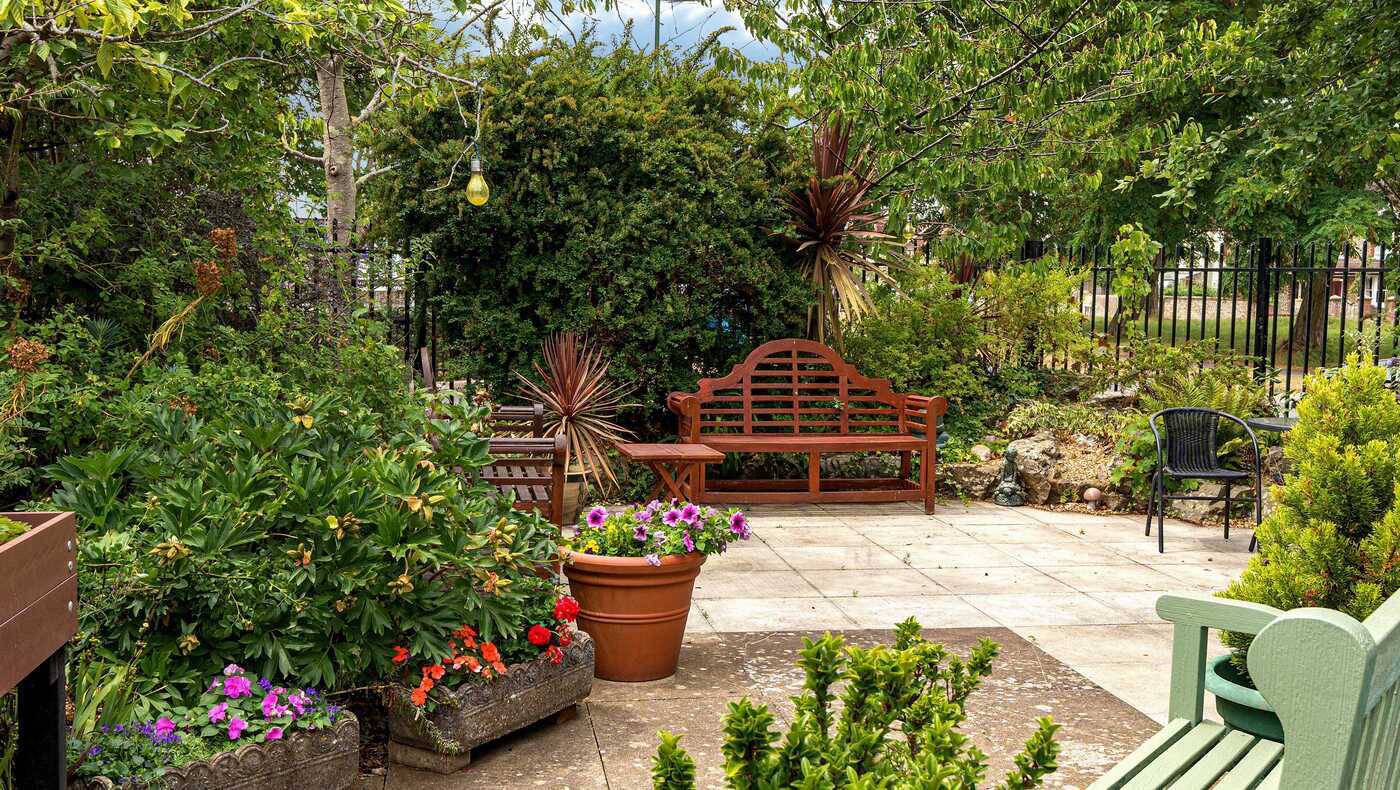 A peaceful outdoor garden area with flowers and benches