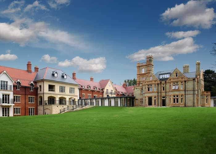 Exterior view of a senior living facility on green lawn