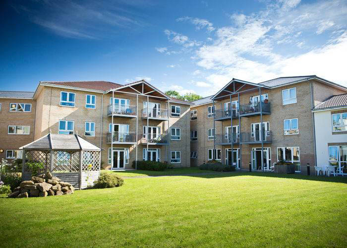 Exterior view of a senior living facility with gardens