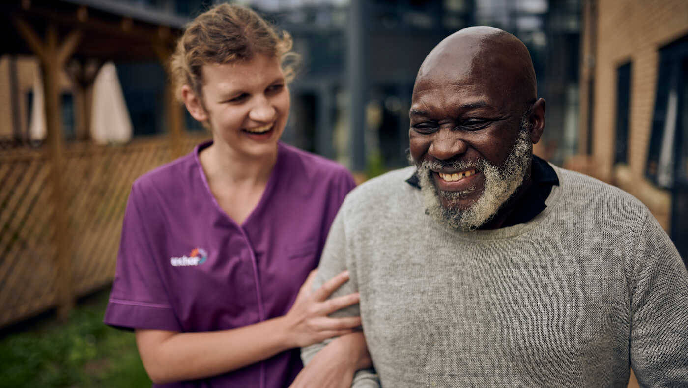 Smiling resident and caregiver enjoying time outdoors
