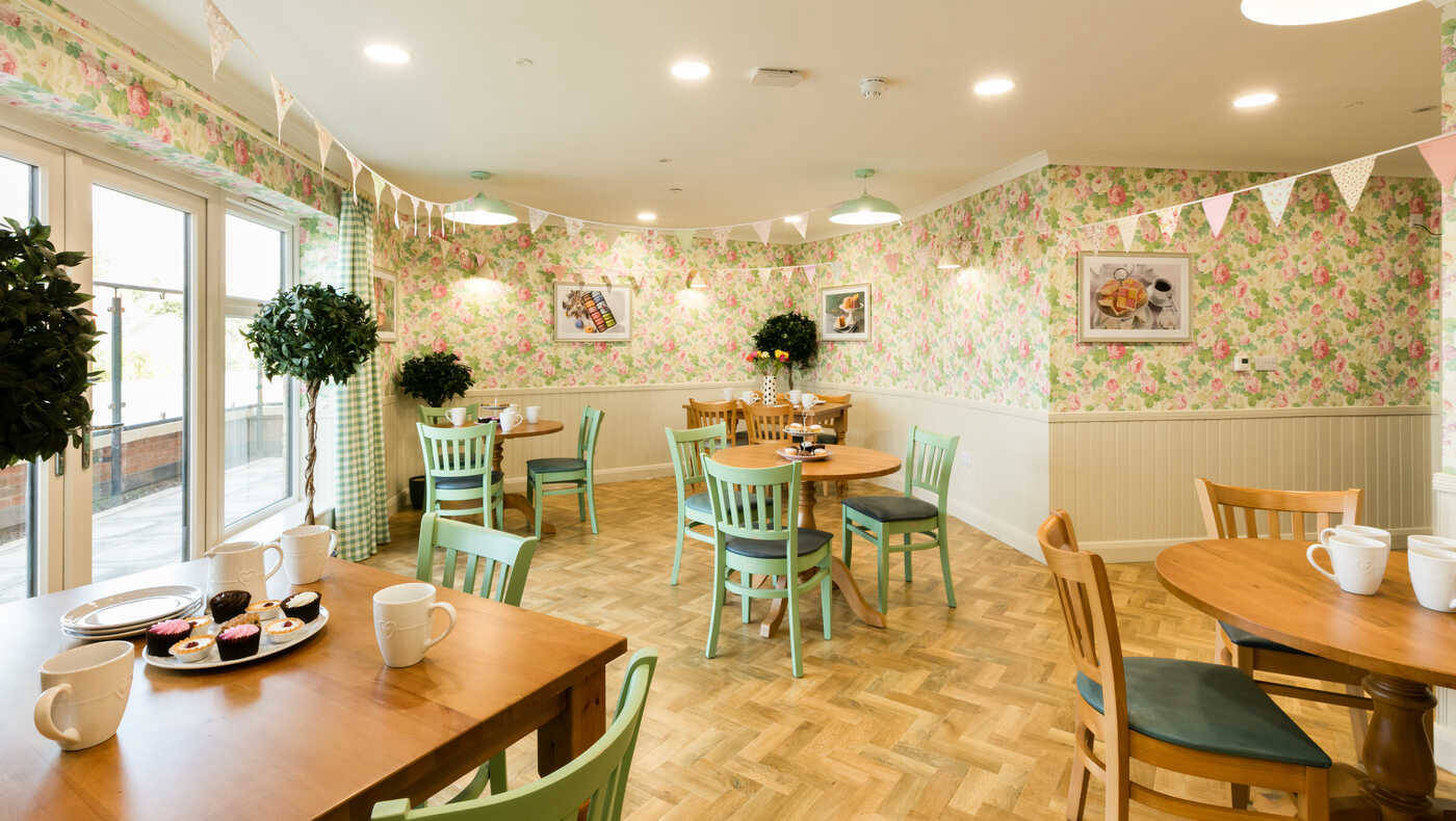Bright dining room with floral wallpaper and tables