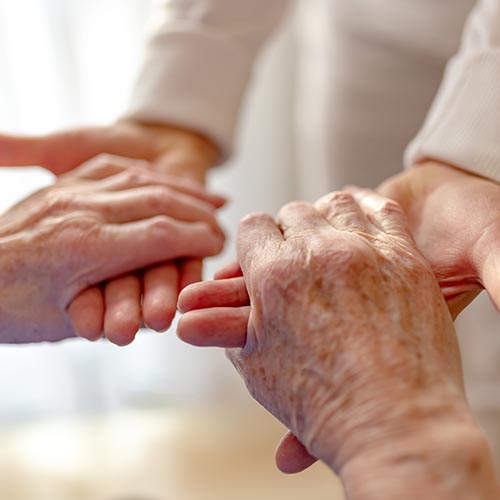Several hands clasped together in care