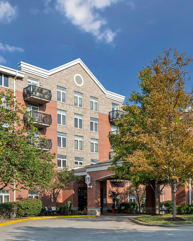Exterior view of the assisted living facility with trees.