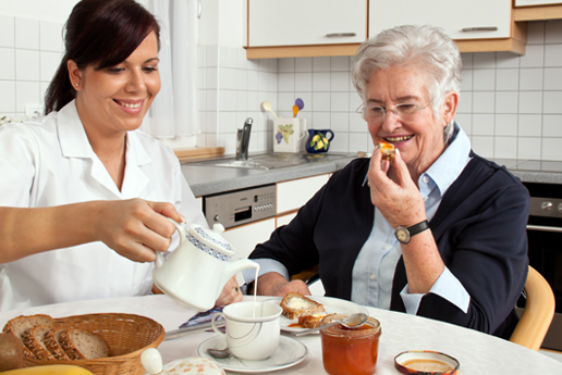 Caregiver serving breakfast to a resident.