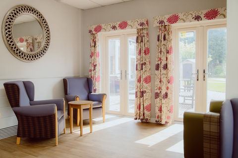Cozy sitting area with comfortable chairs and curtains.
