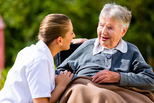 Caregiver interacting with a senior resident outdoors.