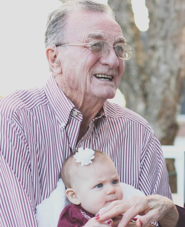 Elderly man smiling with a baby.
