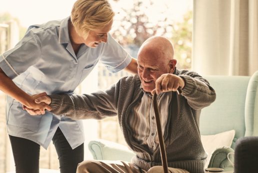 Caregiver assisting an elderly man in a living space