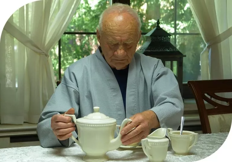 Elderly man enjoying tea by the window