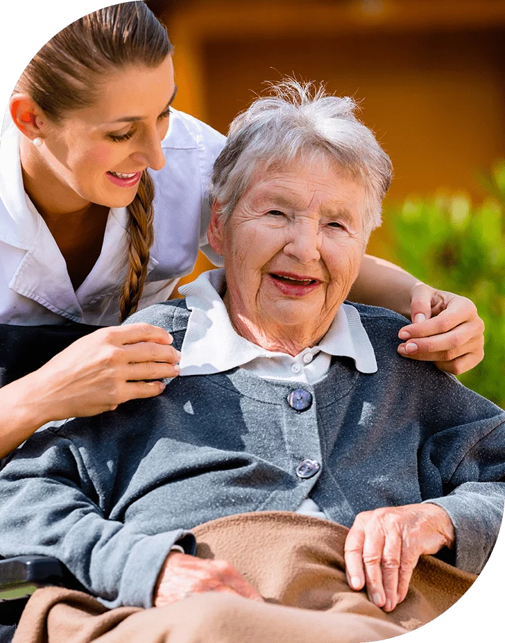 Happy elder woman with caregiver outdoors