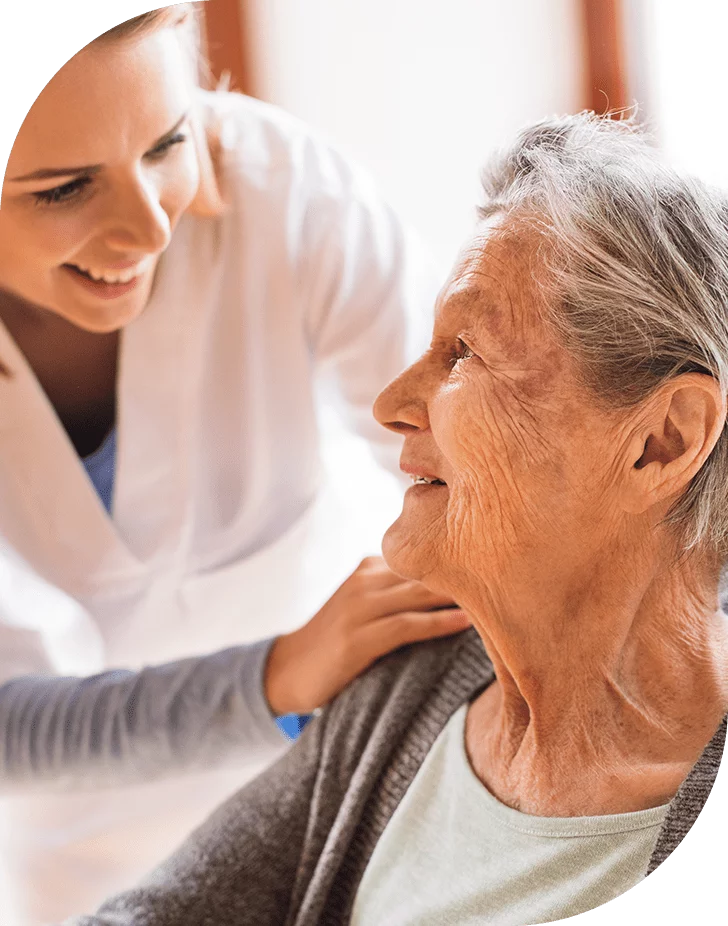 Caregiver interacting with elderly resident in a friendly manner.