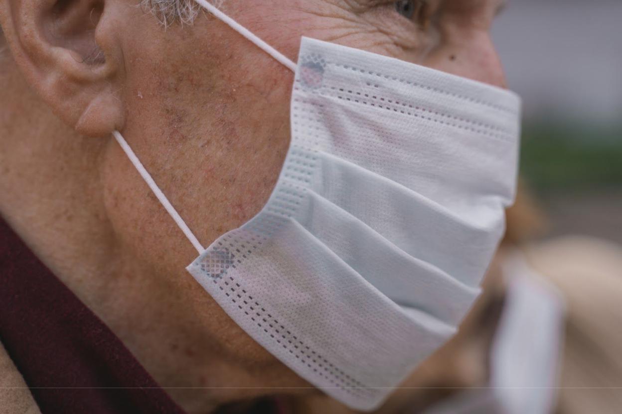 Close-up of an elderly person wearing a mask.