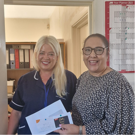 Two staff members smiling in a common area