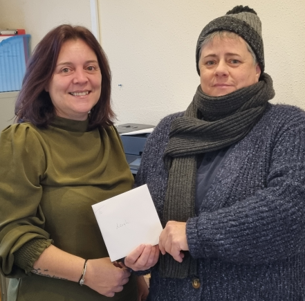 Two staff members posing with a card.