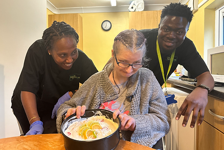 Staff and resident engaging in a baking activity.