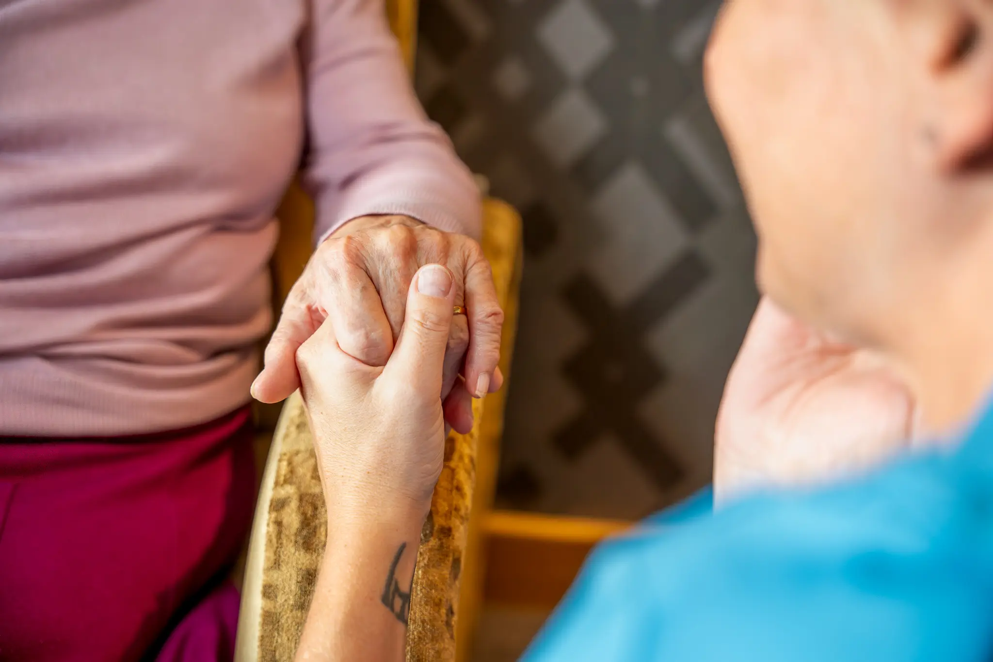 Caregiver and resident holding hands