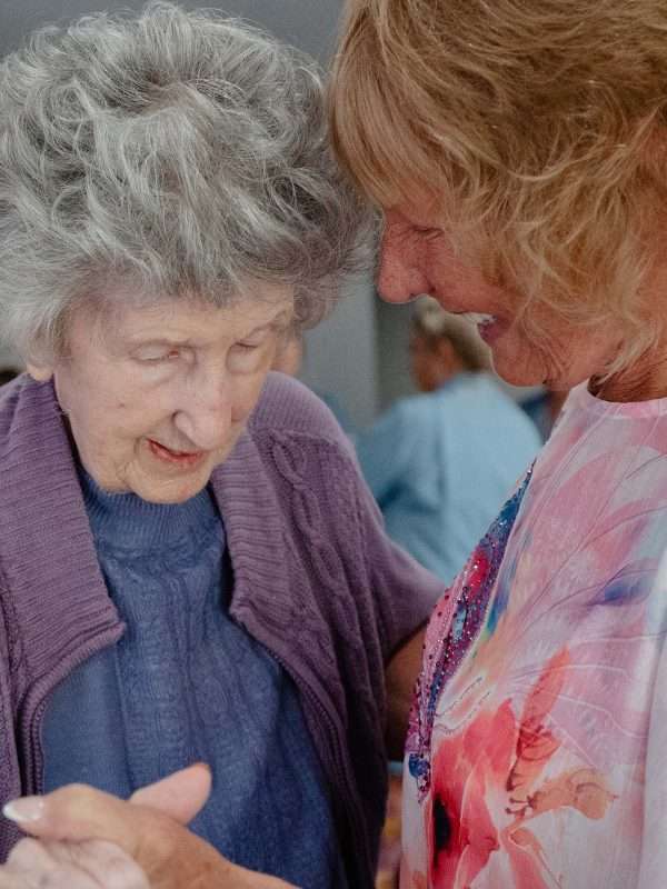 Two women smiling and engaging in activity.