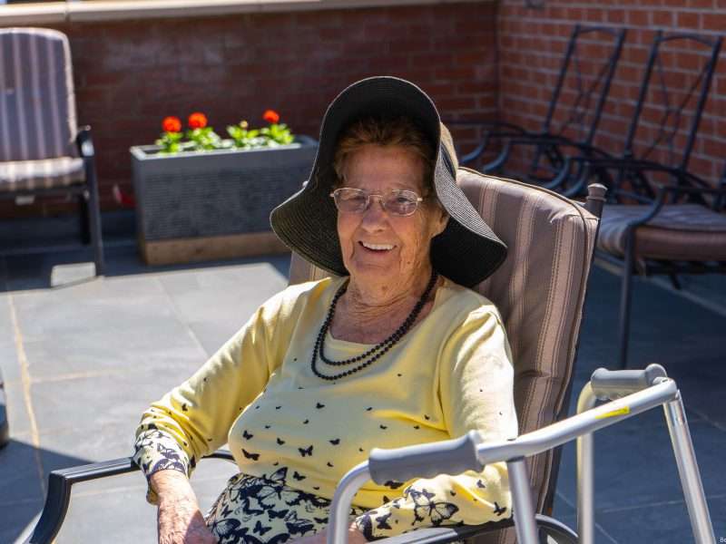 Senior woman smiling outdoors in a sun hat