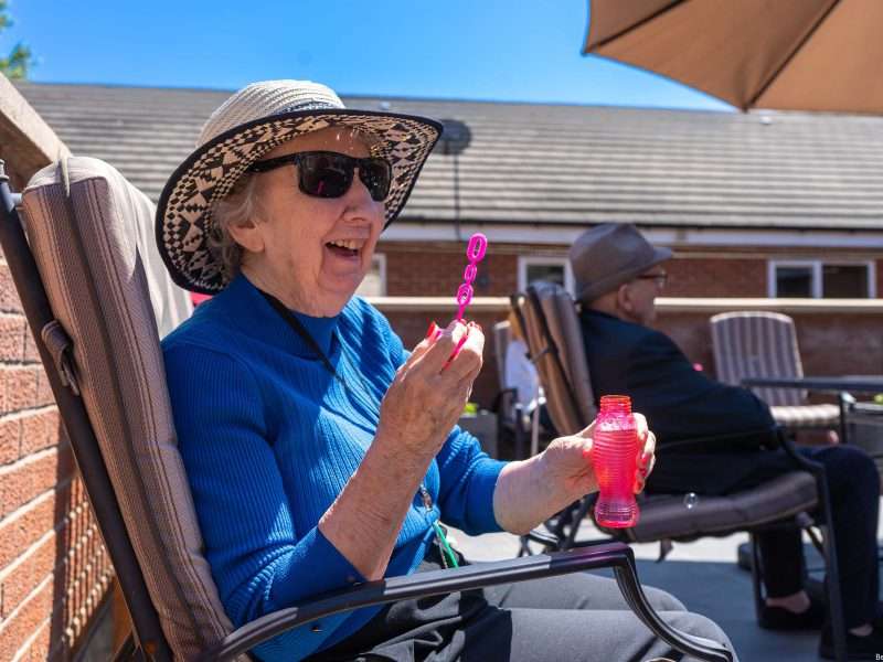 Senior resident enjoying bubbles outdoors