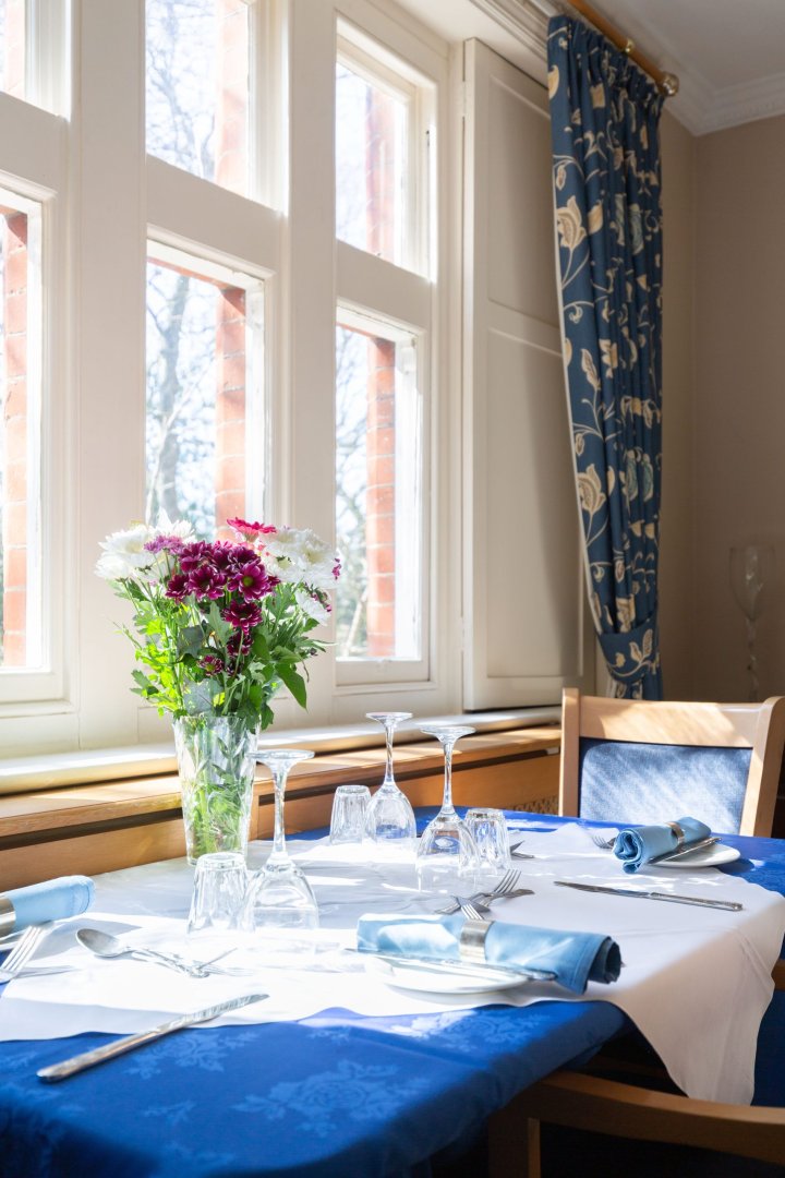 Elegant dining setup with flowers and tableware.