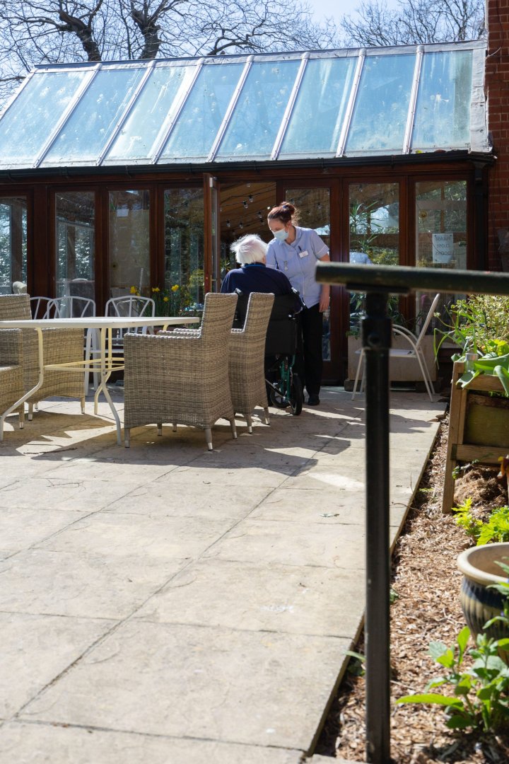 Staff assisting a resident outdoors at Oaklands House.