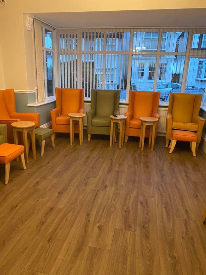 Bright communal lounge area with orange and green chairs.