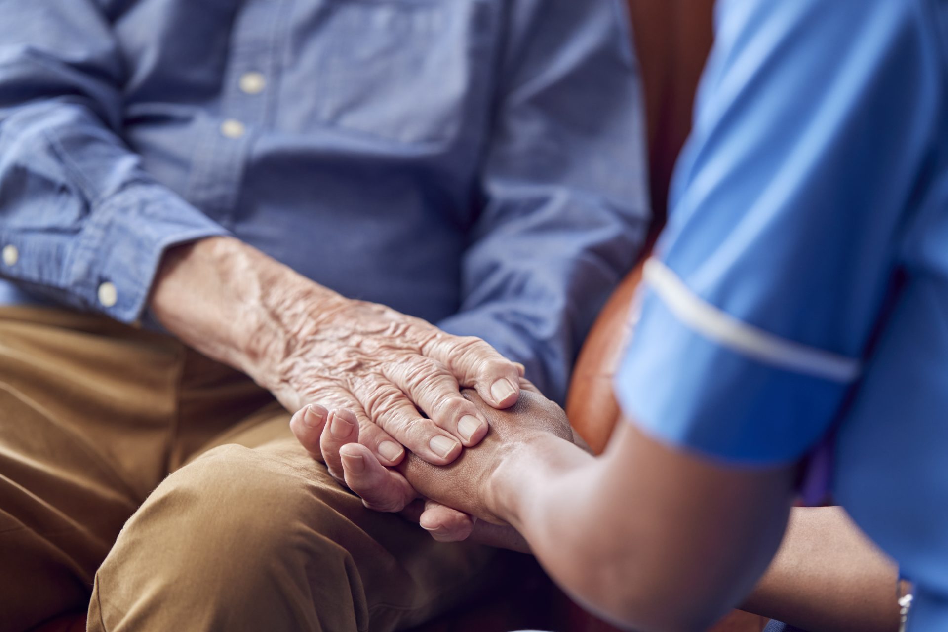 Caregiver holding hands with a senior resident